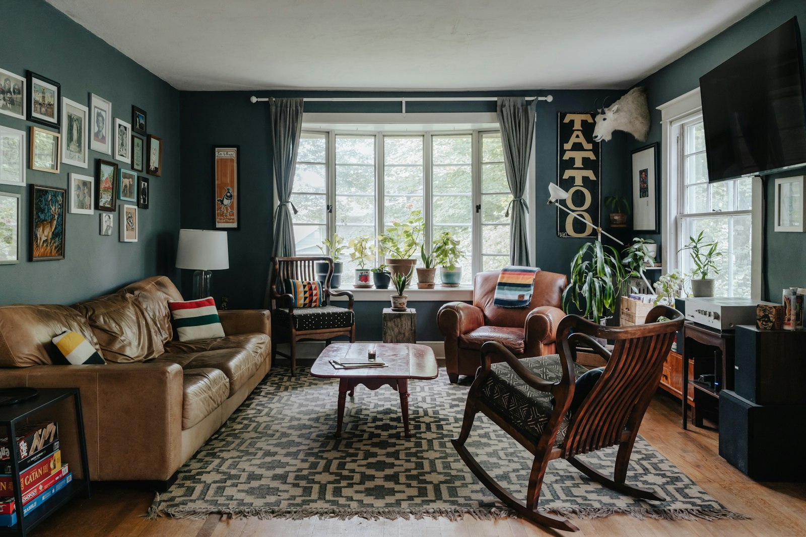 Living room with blue-gray walls, wooden floor and warm evening light