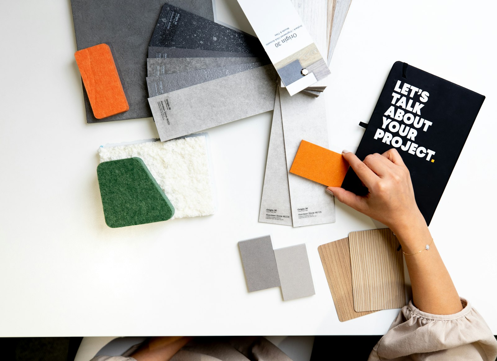 Designer comparing material and color samples on a white desk