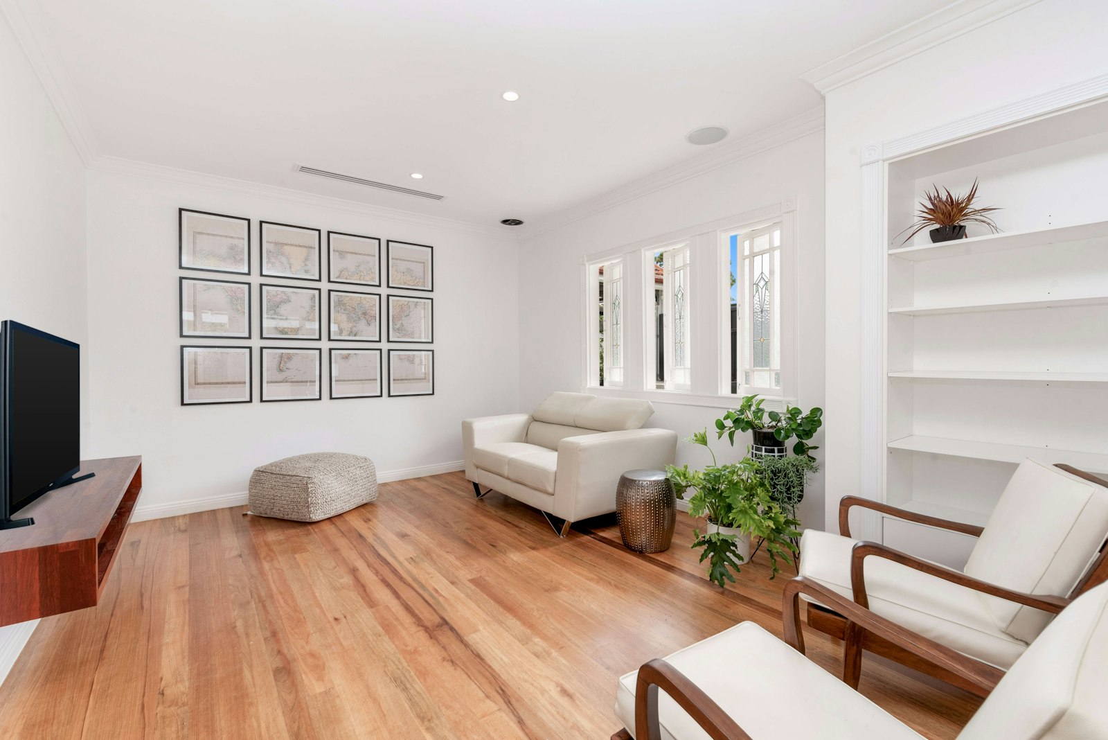 Bright living room with honey-toned natural oak flooring and white walls