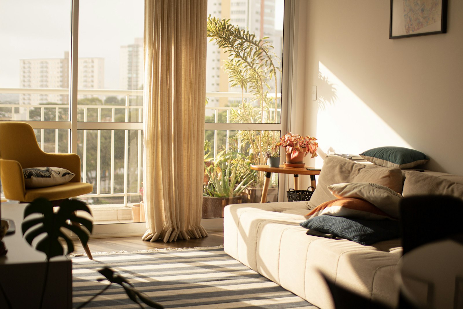 Sunlit living room with a large window and soft curtains